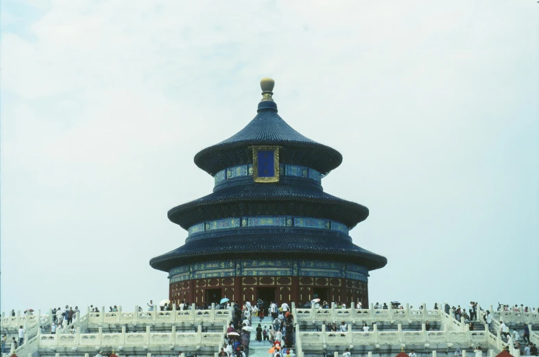 a large pagoda with stairs and people standing near it