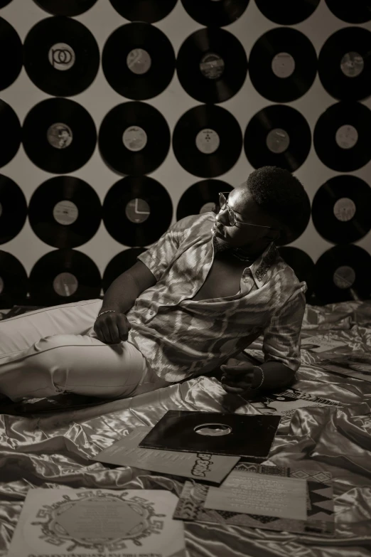 an african man sits on the floor of a room with record records