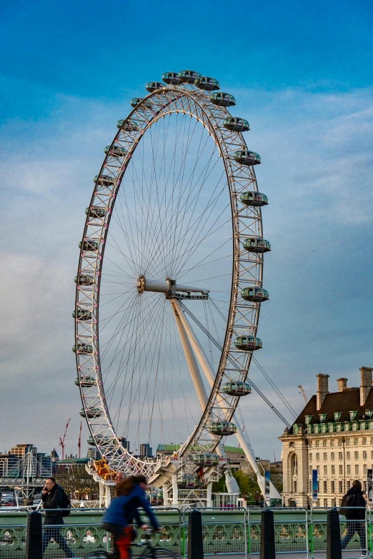 a large ferris wheel on the side of a bridge