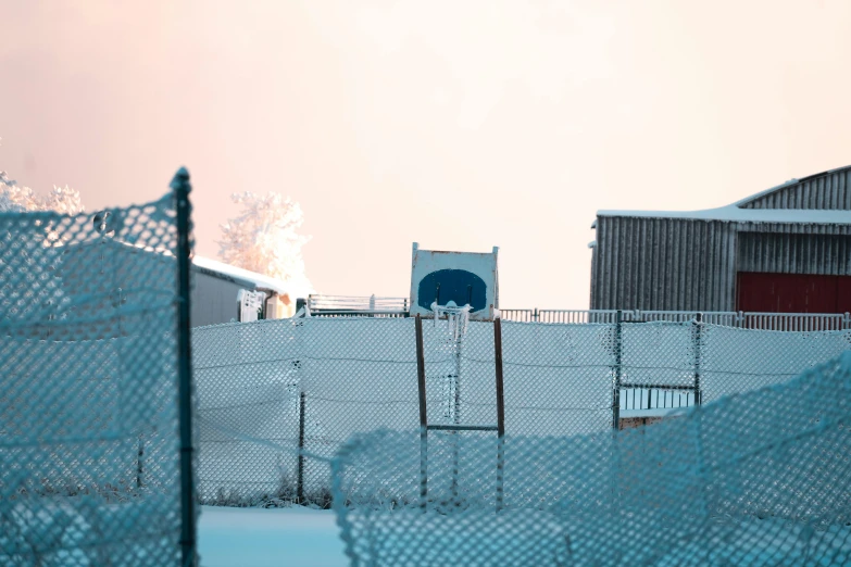several metal fences surrounding a snowy field