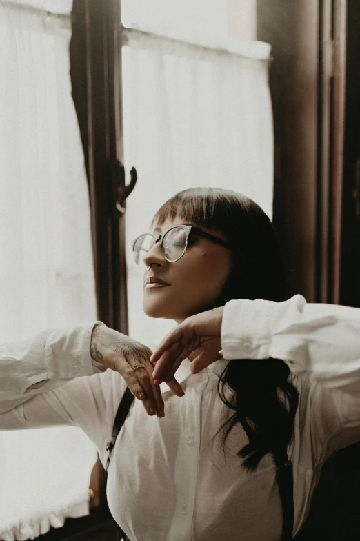 a woman wearing a white shirt is posing with her hands on her lap