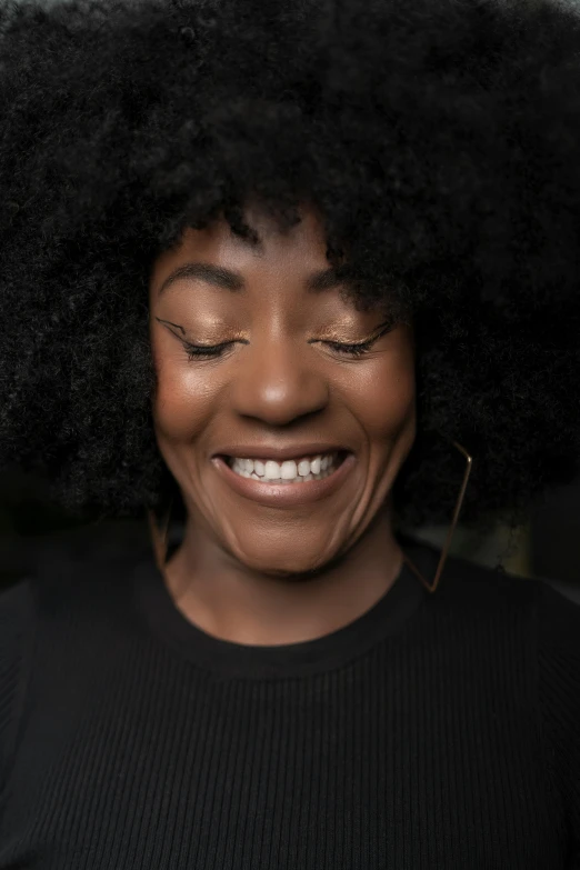 a smiling woman with large afros and a big smile