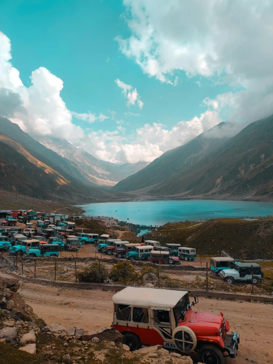 several vehicles parked near each other on the side of the mountain