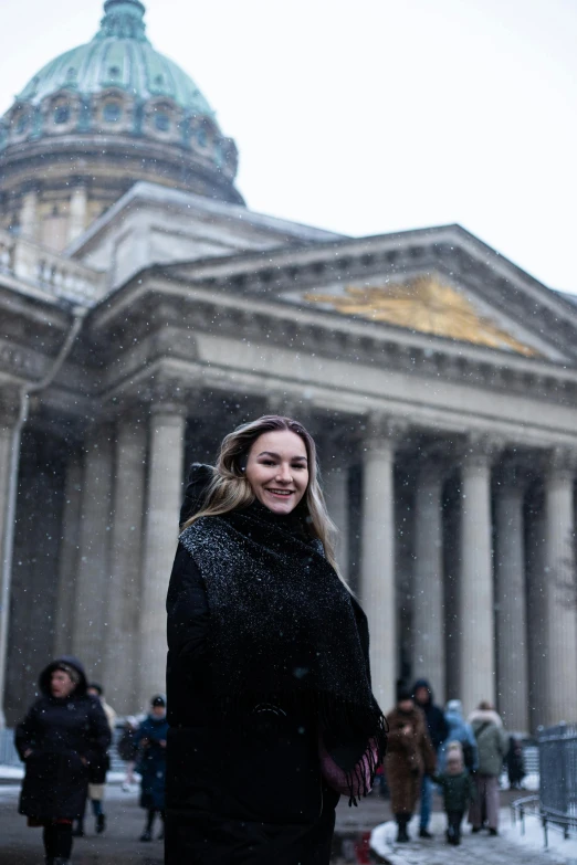 a woman standing outside in front of an old building with columns and a dome