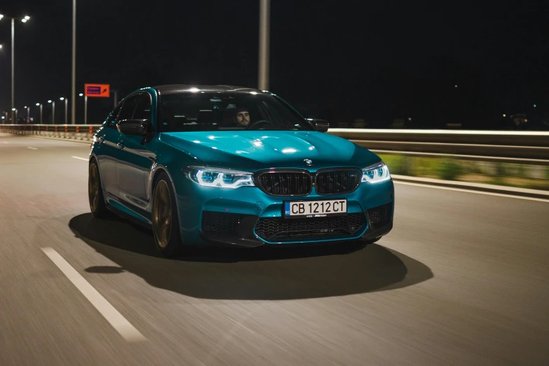 a blue bmw convertible drives down the road