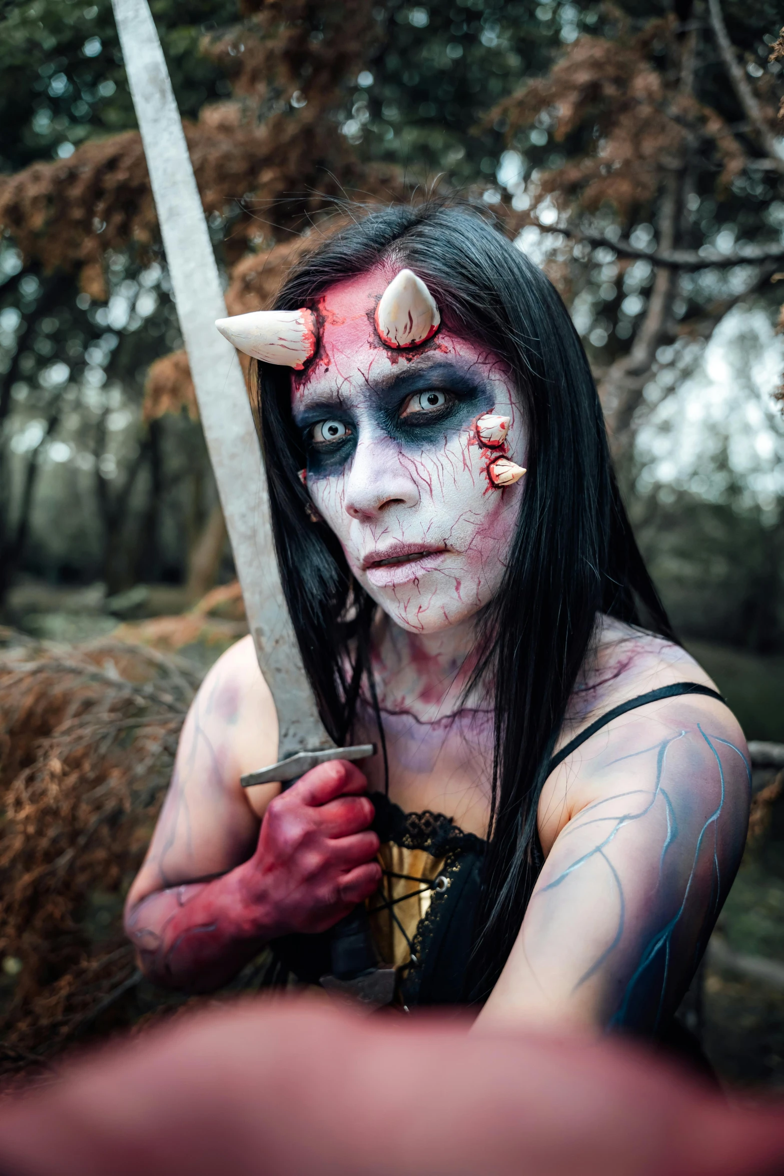 a girl with face paint and a sword on her head