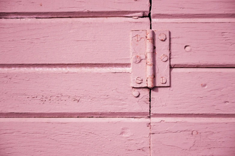 a close up of a wooden wall with pink paint