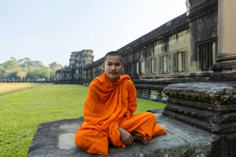 a man is meditating in front of some buildings