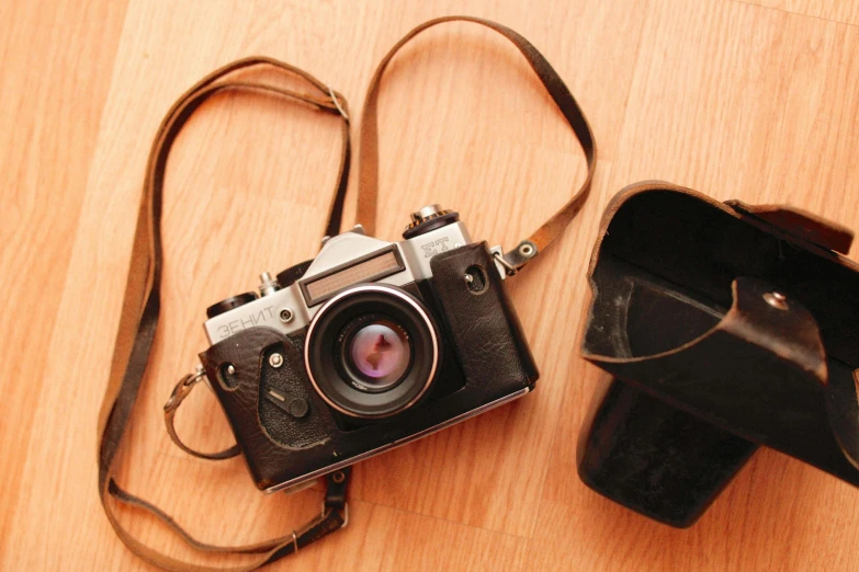 an old camera sitting next to a small case on a table