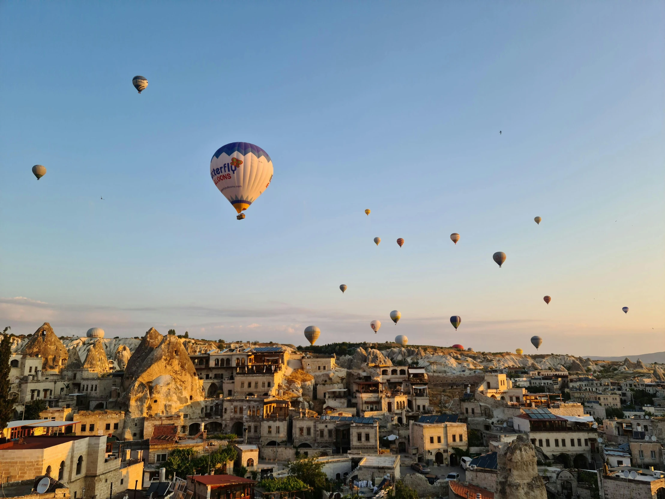 the city skyline has several balloons floating above it