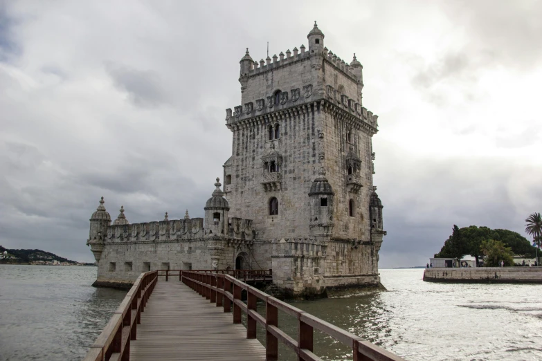 a bridge leading to a large tower on top of a body of water