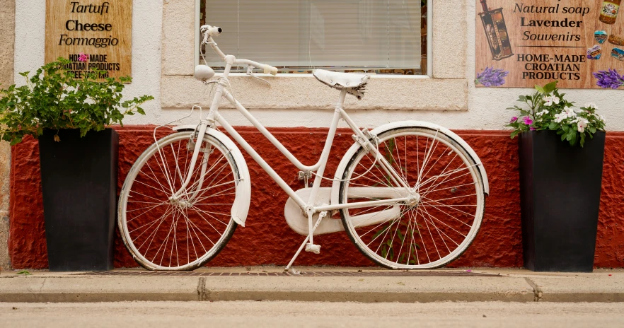 an old white bike parked outside a restaurant