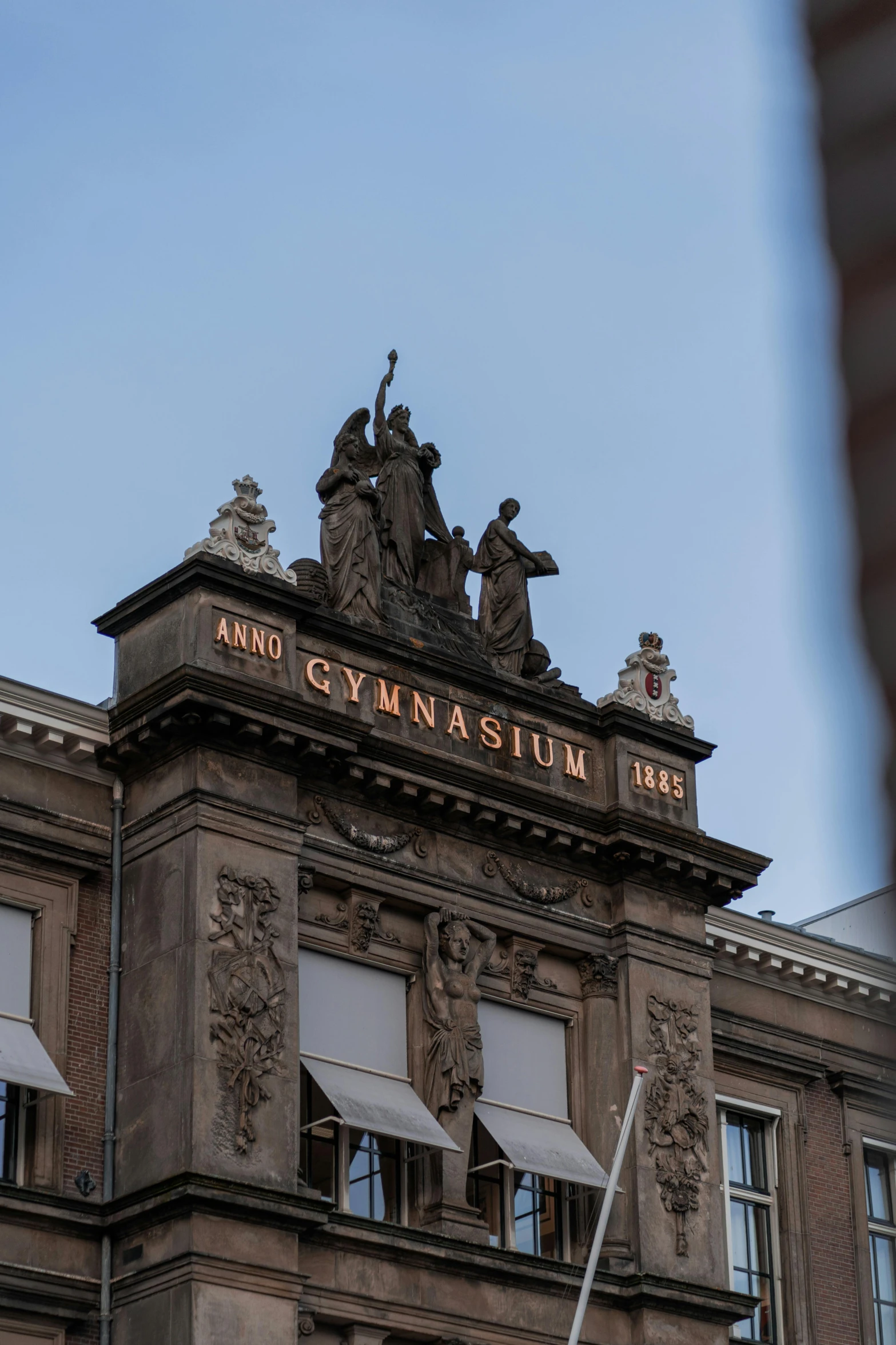 the building has many windows and statues on top