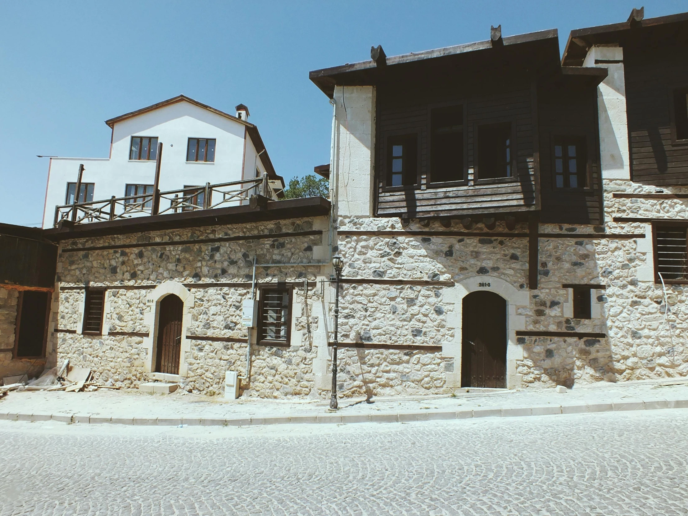 a large brown and black stone house with a balcony