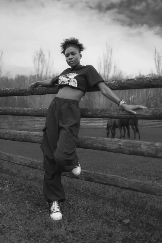 an african american woman jumping in front of a fence with horses