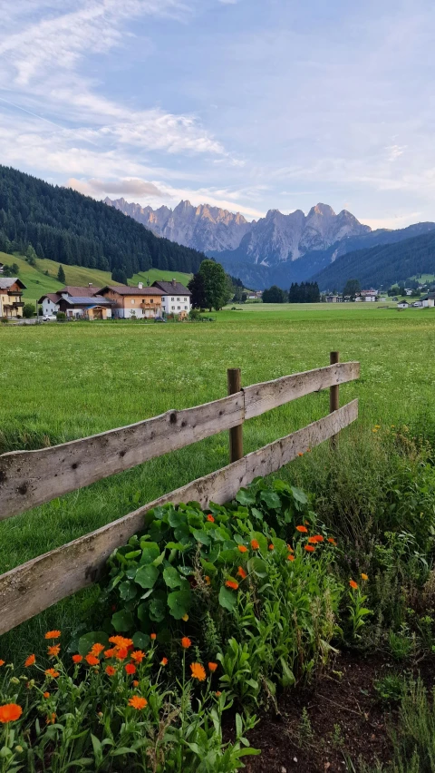 the mountains are behind a wooden fence