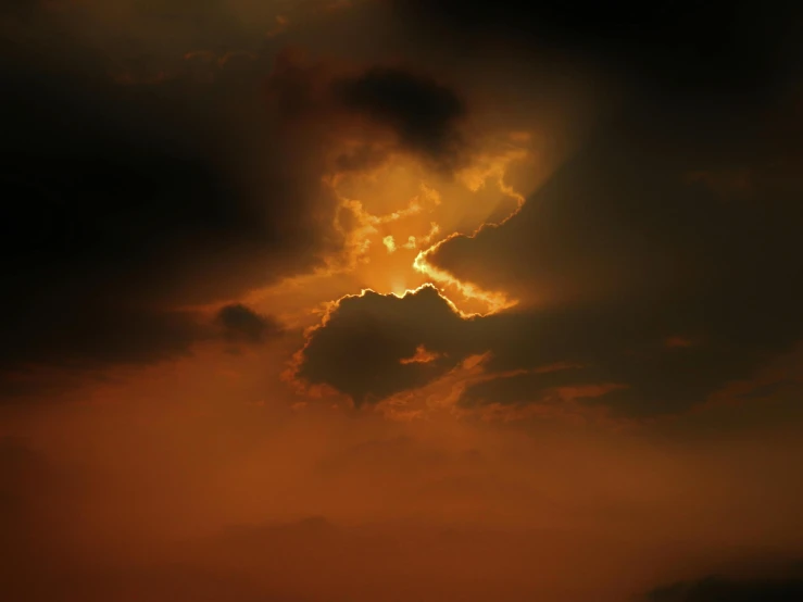 the sun peeking through the clouds on a cloudy day