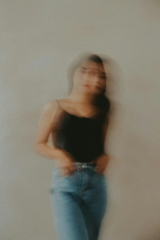 blurry image of woman in black top and jeans