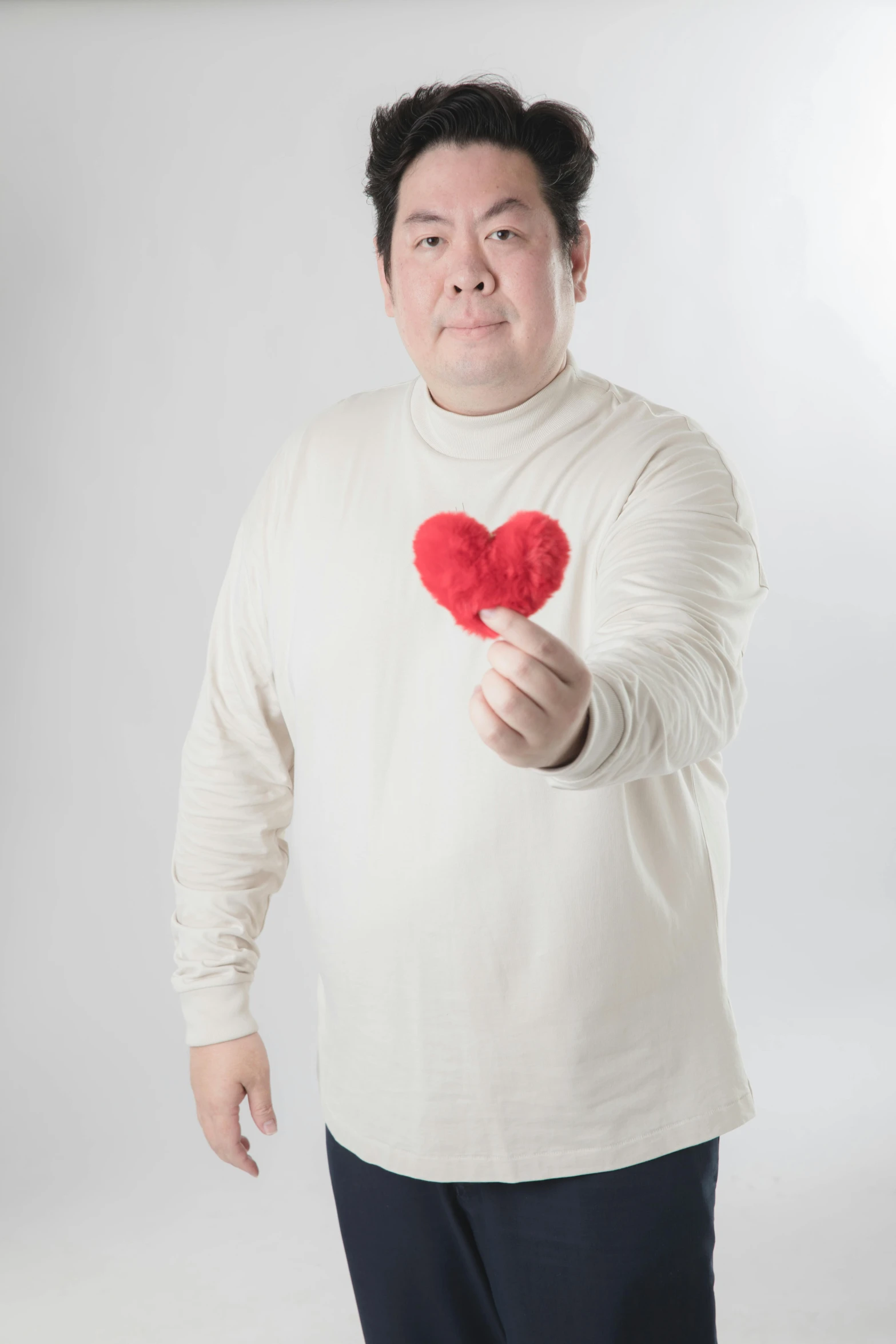 a man holding a red heart with the middle finger