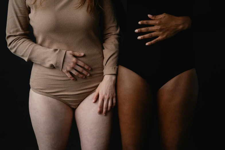 two women in one bodysuit standing up next to each other