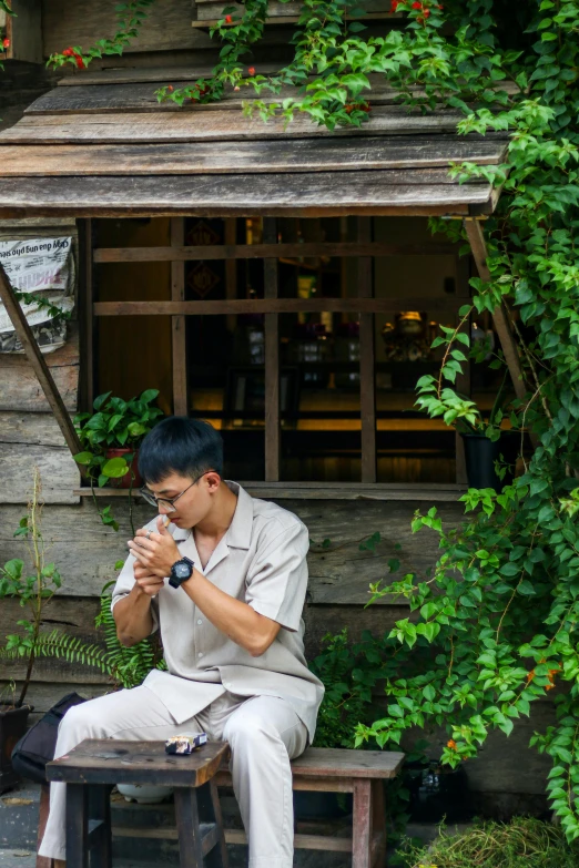 the man is sitting on the bench drinking soing