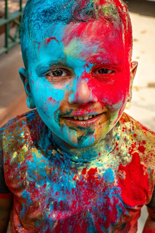 an up close s of a young child with a lot of colorful powder all over his face