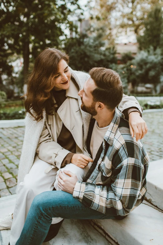 two people sit on a concrete bench laughing