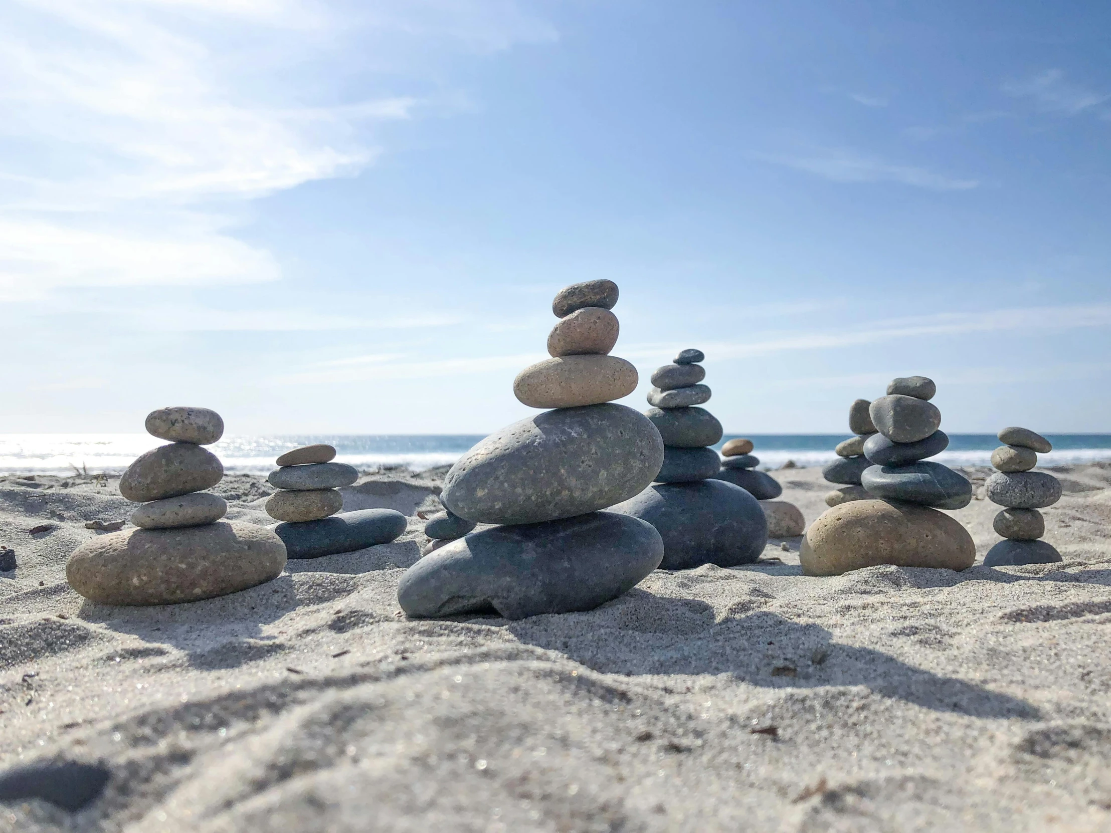 several rocks stacked up in the sand on the beach