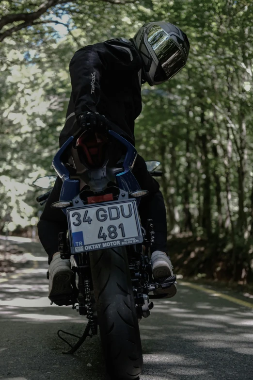 a person on a motorcycle has the license plate of 3 4 ddu