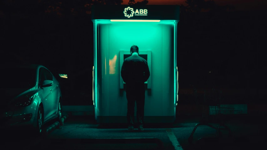 a man stands in a green lit booth