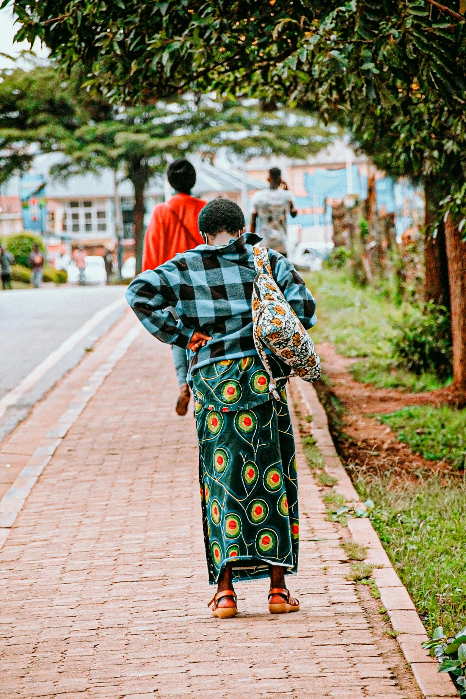 a woman walking down a street carrying a purse