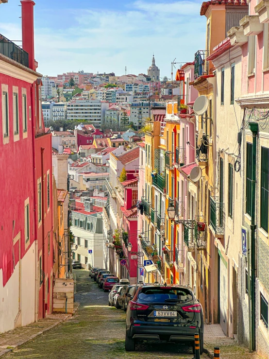 a line of cars sit on a cobblestone road