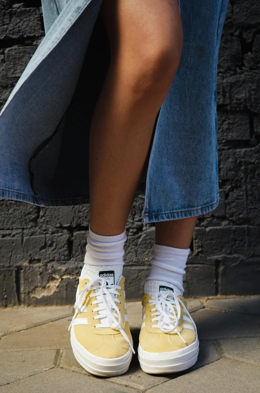 two women wearing yellow shoes and one in blue denim pants