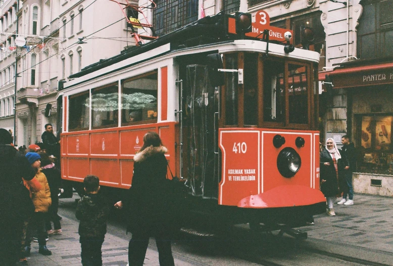 people on the street and a tram on the street