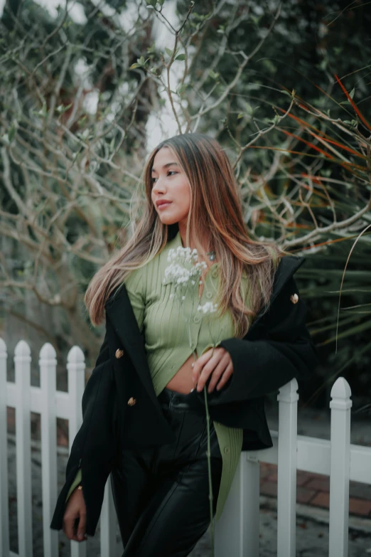 a woman standing behind a white picket fence