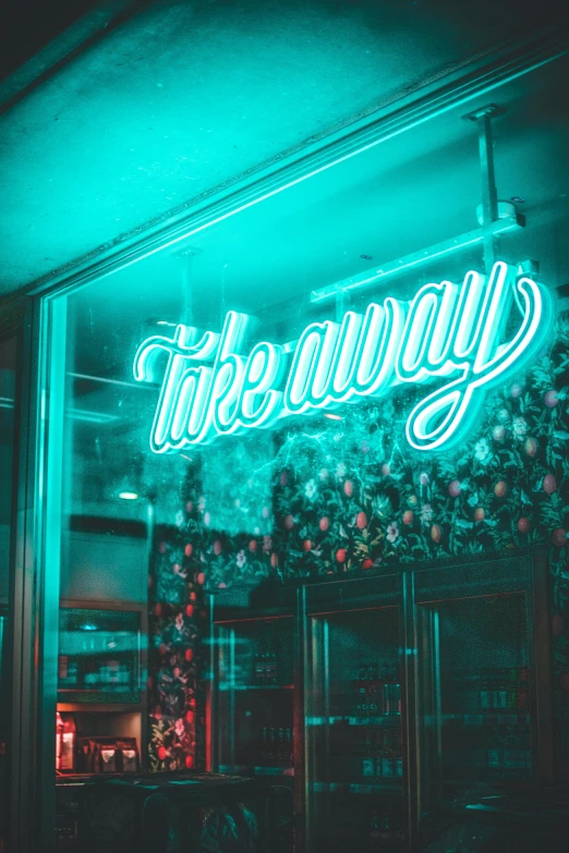 a green neon sign in front of a window