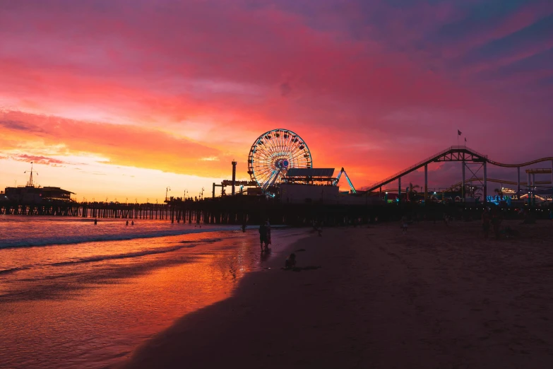 sunset with amut park in background and people walking on beach