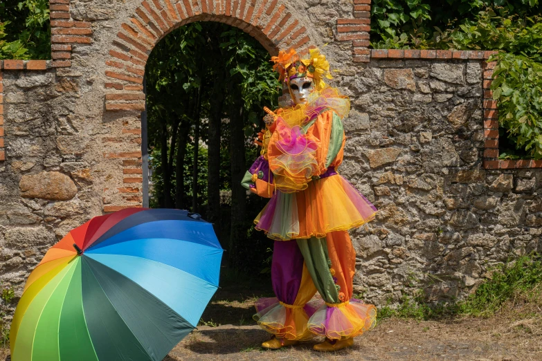 the statue stands beside an open door and two colorful umbrellas