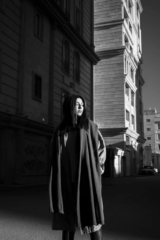 a girl with dreadlocks standing in front of a building