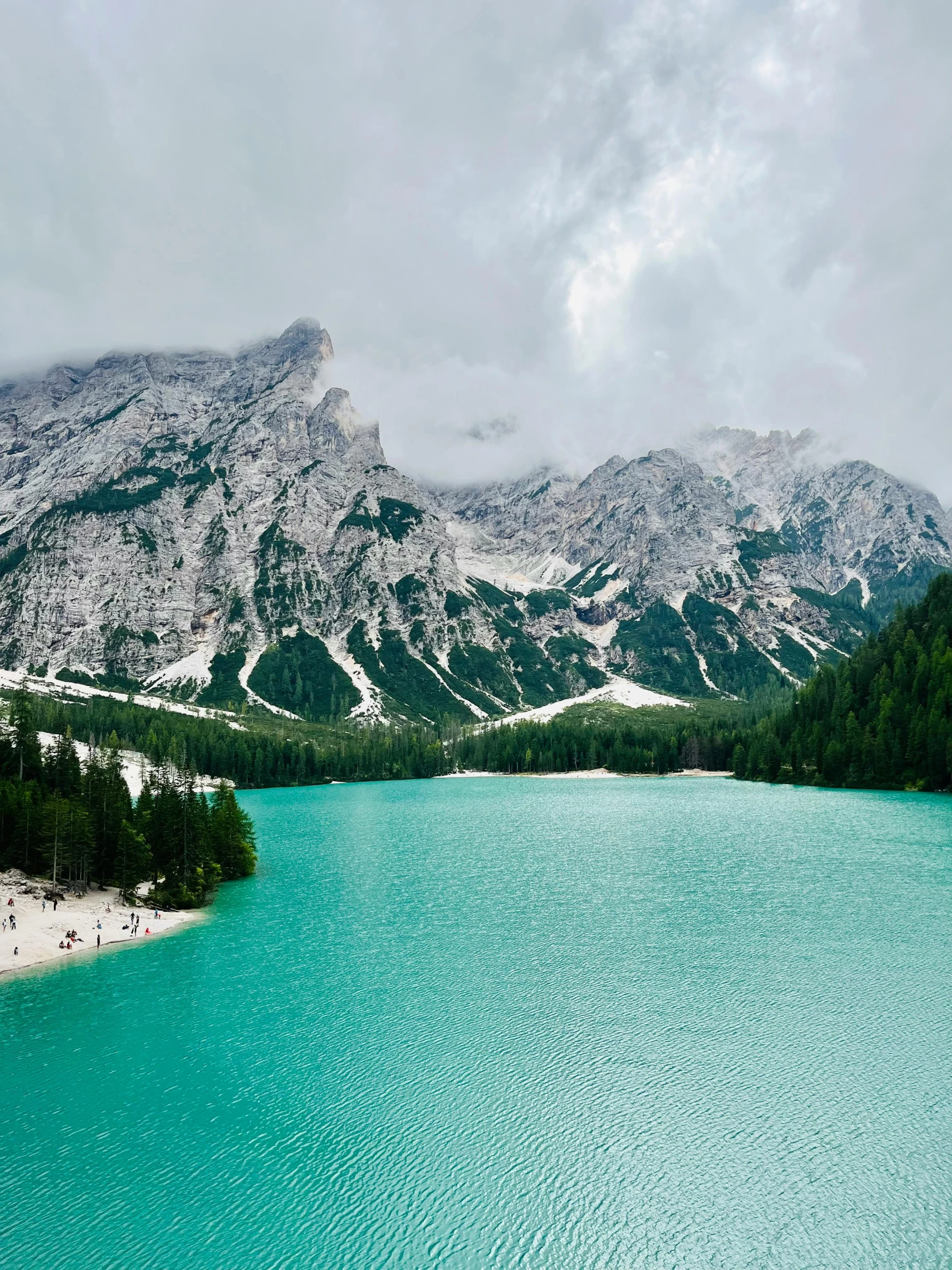 a lake with some very blue water and mountains in the background