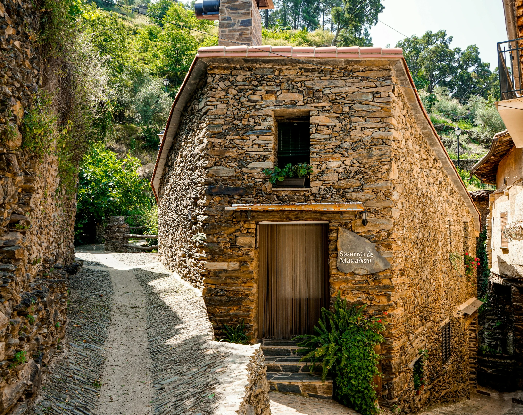 stone house on steep incline path in village