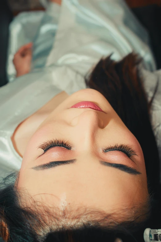 woman sleeping on top of a white sheet covered in hair