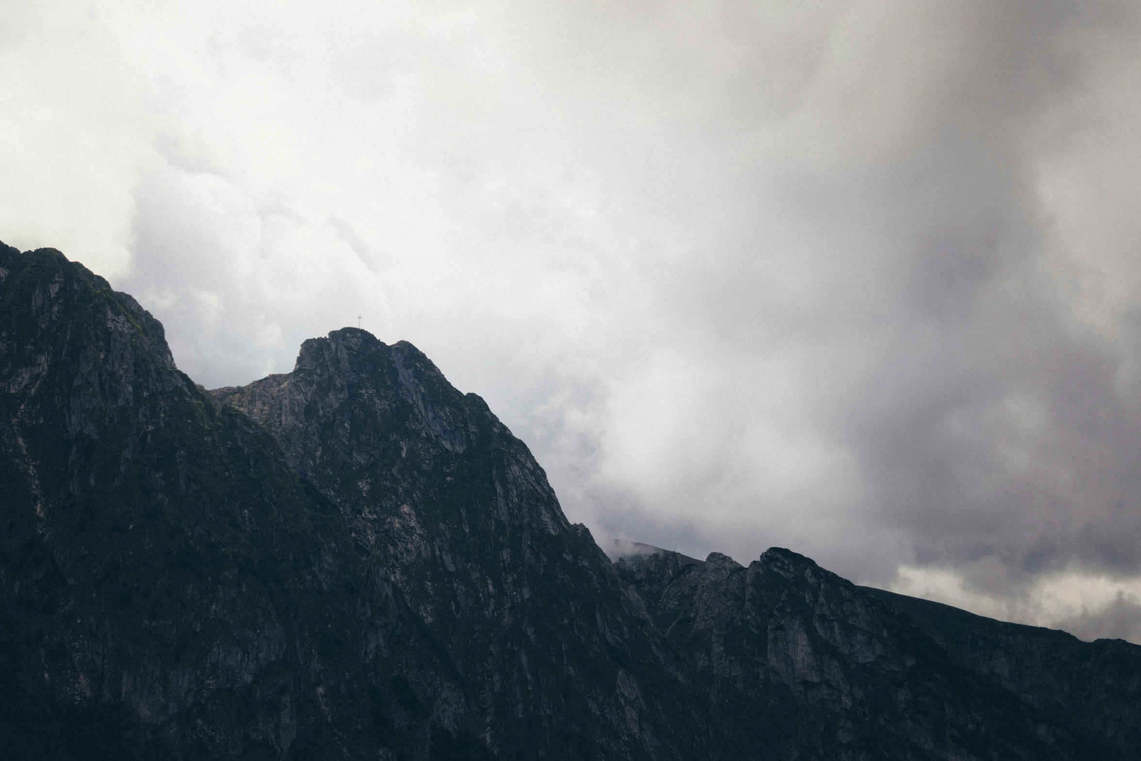 a mountain with gray and dark clouds above it