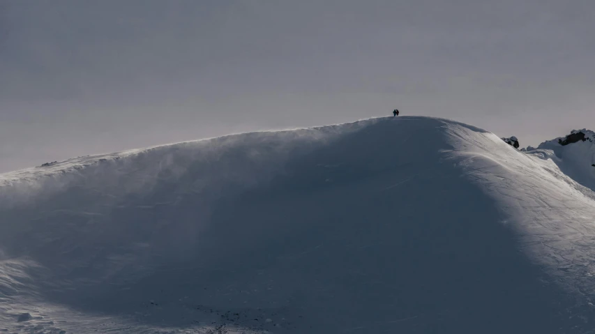 a group of people climbing up the side of a snow covered mountain