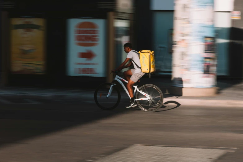 a person riding a bike down the street with a backpack on it