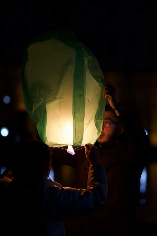 a person holds a lantern in the dark