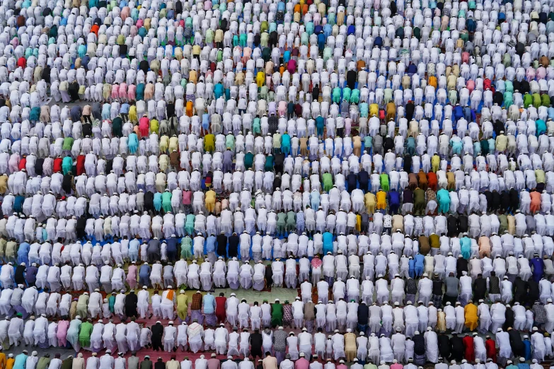 hundreds of people in white, blue and yellow shirts and white ones