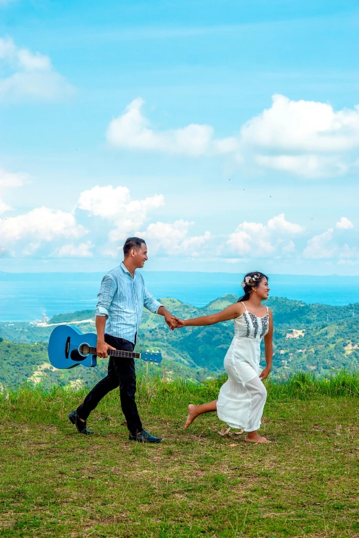 the young couple are on the hill with the sky