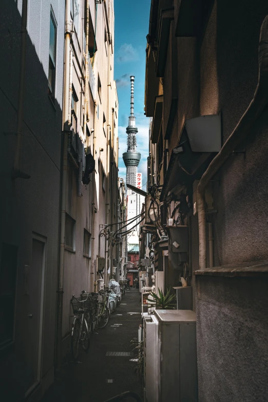 a very narrow alley with a tall building behind it