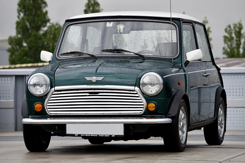 an old green mini - van parked on the pavement